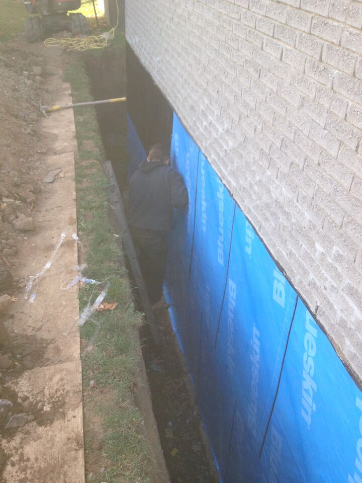 Foundation worker doing foundation waterproofing