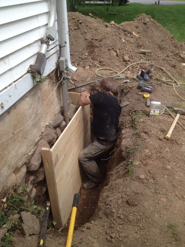 containing-stone-foundation man fixing rubble foundation
